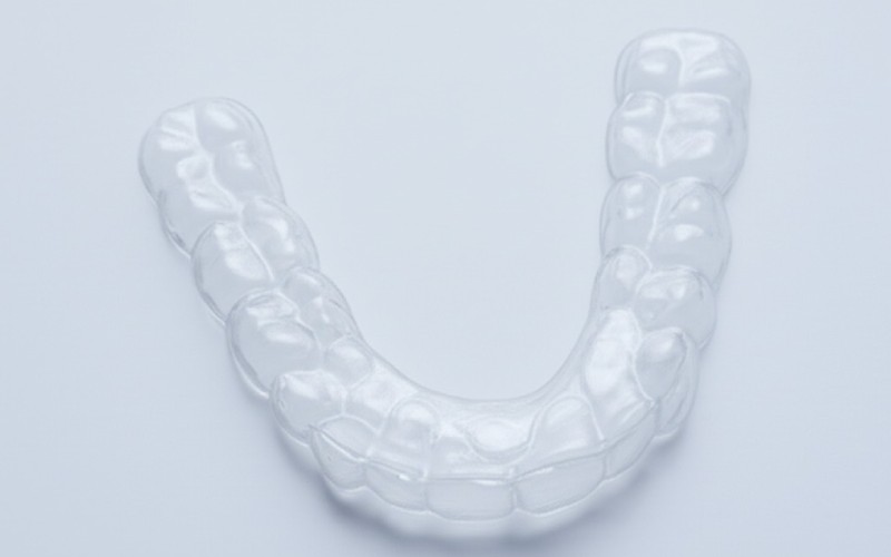 A clear dental aligner for straightening teeth