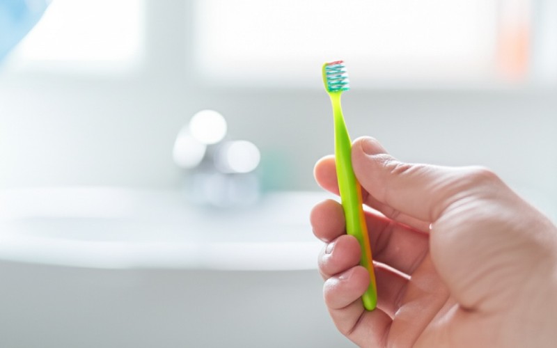 Parent holding a small infant toothbrush