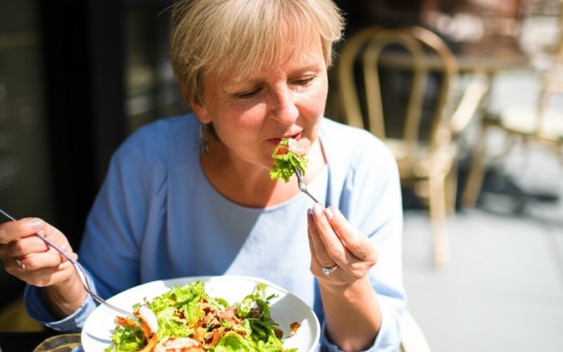 Woman confidently eating a meal outdoors